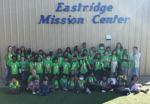 refugee kids in green tshirts standing outside by Eastridge Mission Center
