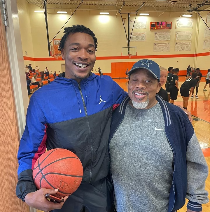 Coach James and young man holding a basketball